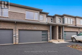 Niagara Falls (Cherrywood) townhouse for rent - A brokerage sign is displayed on a building with a car parked in front.