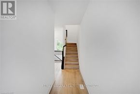 Niagara Falls (Cherrywood) townhouse for rent - A long hallway with a staircase leading to a door at the end.