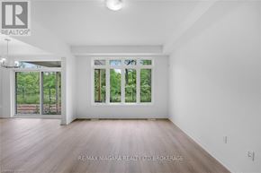 Niagara Falls (Cherrywood) townhouse for rent - A spacious room with a large window and wooden flooring.
