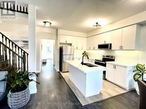 Wasaga Beach apartment for rent - A modern kitchen with white cabinets and a central island.