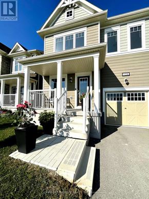 Wasaga Beach apartment for rent - A house with a porch and a garage door.