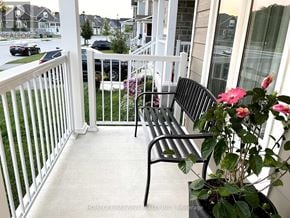 Wasaga Beach apartment for rent - A black bench sits on a white porch.