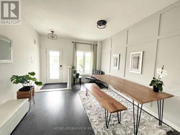Wasaga Beach apartment for rent - A modern living room with a long wooden table and a bench.