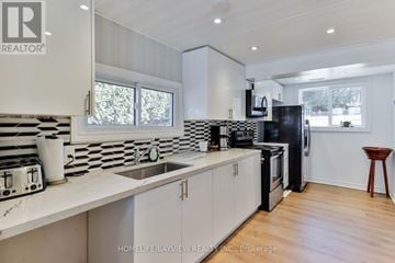 Alderville First Nation apartment for rent - A modern kitchen with white cabinets and black appliances.
