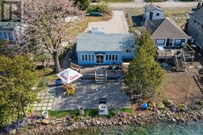 Alderville First Nation apartment for rent - A house with a blue roof and a patio with chairs and an umbrella.
