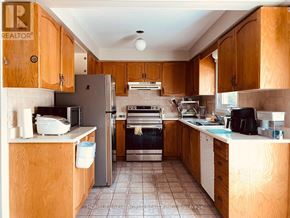 Richmond Hill (South Richvale) apartment for rent - A kitchen with wooden cabinets and a stainless steel refrigerator.