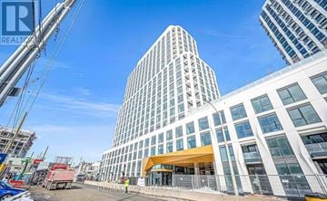 Toronto (Islington-City Centre West) condo for rent - A modern building with a glass facade stands tall in an urban setting.