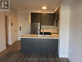 Milton (Wi Willmott) condo for rent - A kitchen with a refrigerator, sink, and cabinets.