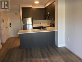 Milton (Wi Willmott) condo for rent - A kitchen with a stainless steel refrigerator and dark wood flooring.