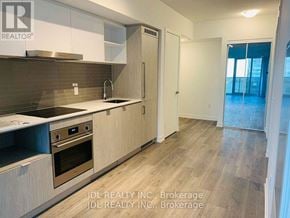 Toronto (Waterfront Communities) condo for rent - A kitchen with wooden cabinets and a stainless steel oven.