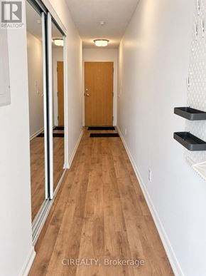 Toronto (Niagara) condo for rent - A hallway with a wooden floor and white walls.