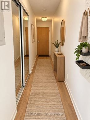 Toronto (Niagara) condo for rent - A hallway with a carpeted floor and a wooden door.