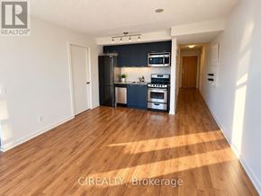 Toronto (Niagara) condo for rent - A kitchen with wooden floors and white walls.