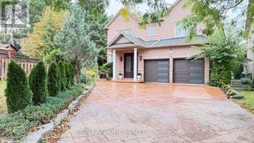 Markham (Thornlea) apartment for rent - A house with a driveway and garage doors is for sale.