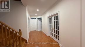 Markham (Thornlea) apartment for rent - A hallway with a wooden staircase and white walls.