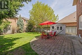 Oakville (Wm Westmount) apartment for rent - A backyard with a table and chairs and a red umbrella.