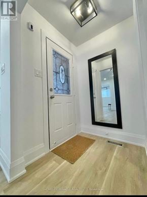 Brampton (Brampton West) apartment for rent - A hallway with a white door and a mirror on the wall.