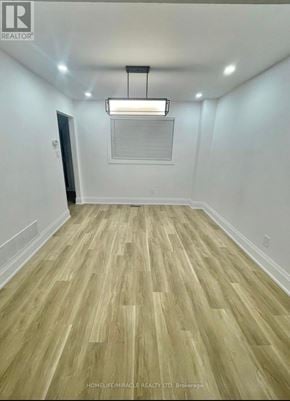 Brampton (Brampton West) apartment for rent - A room with wooden flooring and a light hanging from the ceiling.