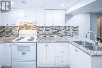 Brampton (Northwest Brampton) apartment for rent - A kitchen with white cabinets and a stone backsplash.
