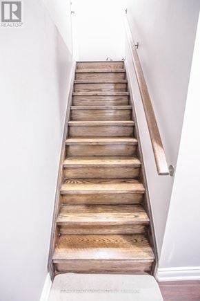 Brampton (Northwest Brampton) apartment for rent - A wooden staircase with a white wall on the side.