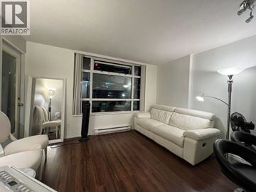 Vancouver apartment for rent - A living room with a white couch and a black chair.