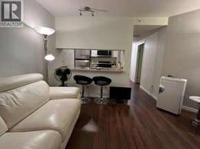 Vancouver apartment for rent - A living room with a white couch and a wooden floor.