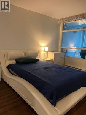 Vancouver apartment for rent - A bed with a blue comforter and two white pillows.