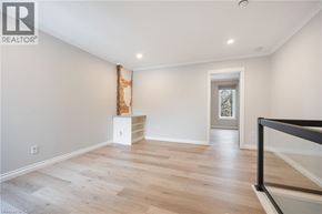 Hamilton townhouse for rent - A spacious room with wooden flooring and a white cabinet.
