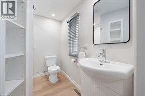 Hamilton townhouse for rent - A white toilet sits in a bathroom next to a sink.