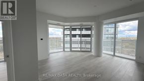 Vaughan (Steeles West Industrial) condo for rent - A spacious room with a view of the cityscape through large windows.