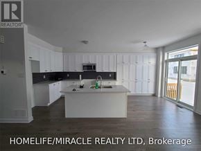 Ottawa apartment for rent - A modern kitchen with white cabinets and a central island.