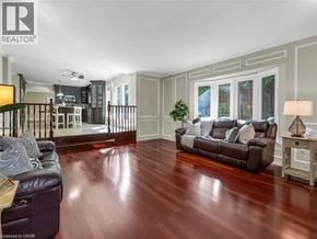 Ancaster apartment for rent - A living room with a brown leather couch and wooden floors.