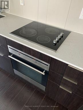 Toronto (Regent Park) condo for rent - A modern kitchen with a stainless steel oven and a wooden cabinet.
