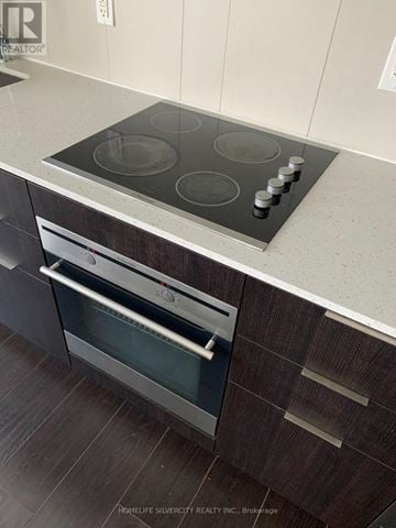 Toronto (Regent Park) condo for rent - A modern kitchen with a stainless steel oven and a wooden cabinet.