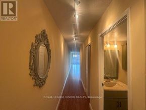 Toronto (Waterfront Communities) condo for rent - A hallway with a mirror on the wall and a light on the ceiling.