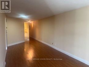 Toronto (Waterfront Communities) condo for rent - A room with wooden flooring and white walls, with a doorway leading to another room.