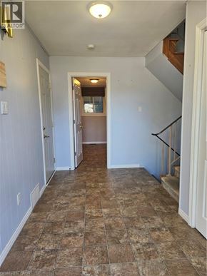 Kitchener apartment for rent - A hallway with tiled flooring and a staircase on the right.