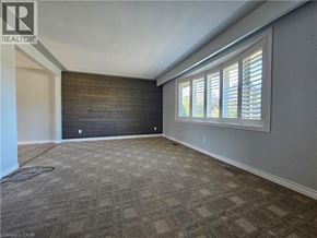 Kitchener apartment for rent - A room with a carpeted floor and a window with blinds.
