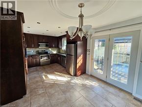 Kitchener apartment for rent - A well-lit kitchen with brown cabinets and a chandelier.