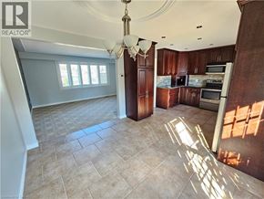 Kitchener apartment for rent - A well-lit kitchen with wooden cabinets and a tiled floor.