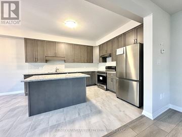 Pelham (Fonthill) townhouse for rent - A kitchen with a stainless steel refrigerator, oven, and microwave.