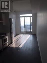 Toronto (Niagara) condo for rent - A realtor's image of a large, empty room with a view of the outside.