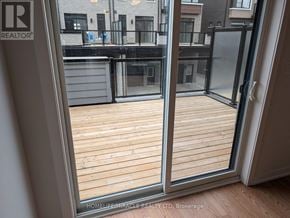 Toronto (Bendale) townhouse for rent - A balcony with a glass door leading to a wooden deck.