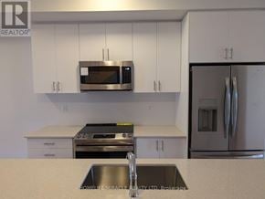 Toronto (Bendale) townhouse for rent - A kitchen with white cabinets and a stainless steel refrigerator.