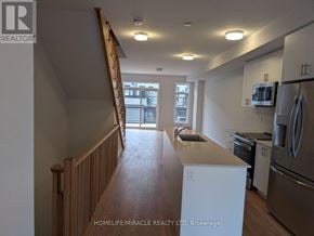 Toronto (Bendale) townhouse for rent - A kitchen with white appliances and wooden floors.