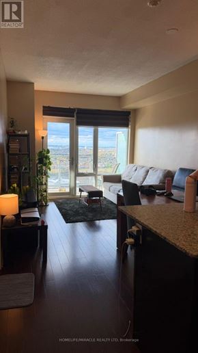 Mississauga (City Centre) condo for rent - A living room with a view of the city through the window.