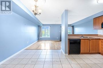 Brampton (Sandringham-Wellington) townhouse for rent - A kitchen with a black dishwasher and wooden cabinets.