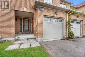 Brampton (Sandringham-Wellington) townhouse for rent - A brick house with a white garage door and a small garden in front.