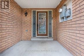 Brampton (Sandringham-Wellington) townhouse for rent - A door with a glass panel and a metal frame is set in a brick wall.