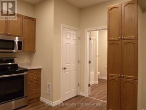 Woodstock (Woodstock - North) apartment for rent - A kitchen with wooden cabinets and a white door.
